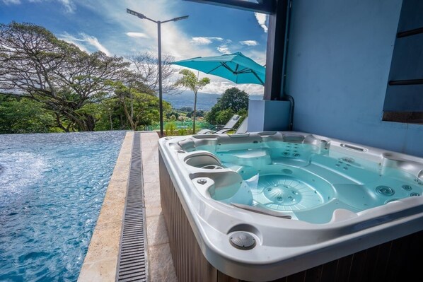Un bain à remous avec vue sur un paysage luxuriant et un ciel dégagé.