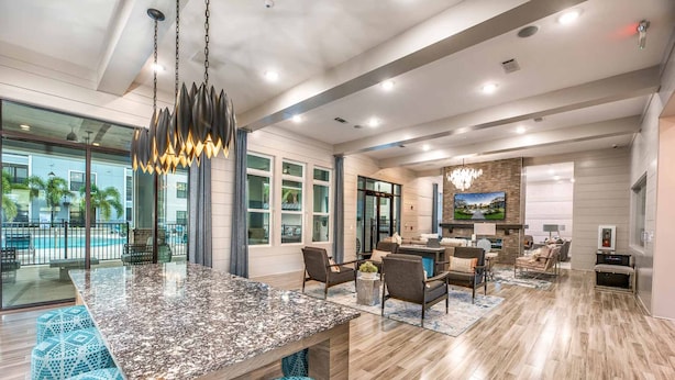 Un amplio salón con una isla grande, asientos cómodos y una lámpara moderna.