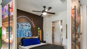 A modern bedroom with a bed, a ceiling fan, and a wall mural. - Deep Ellum | 4 Ppl | Walkable | Great Views (Dallas)