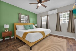 Ein Schlafzimmer mit einem Bett, einem Nachttisch und einem Deckenventilator.