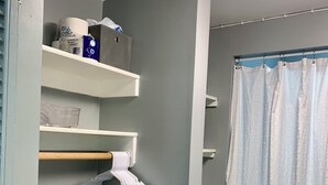 Een badkamer met grijze wanden, een douchegordijn en een witte handdoekhouder.
