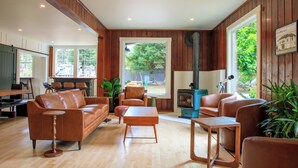 A spacious living room with a wooden floor, leather sofas, a coffee table, and a fireplace. - The Historic Schoolhouse Inn   (Trinidad)