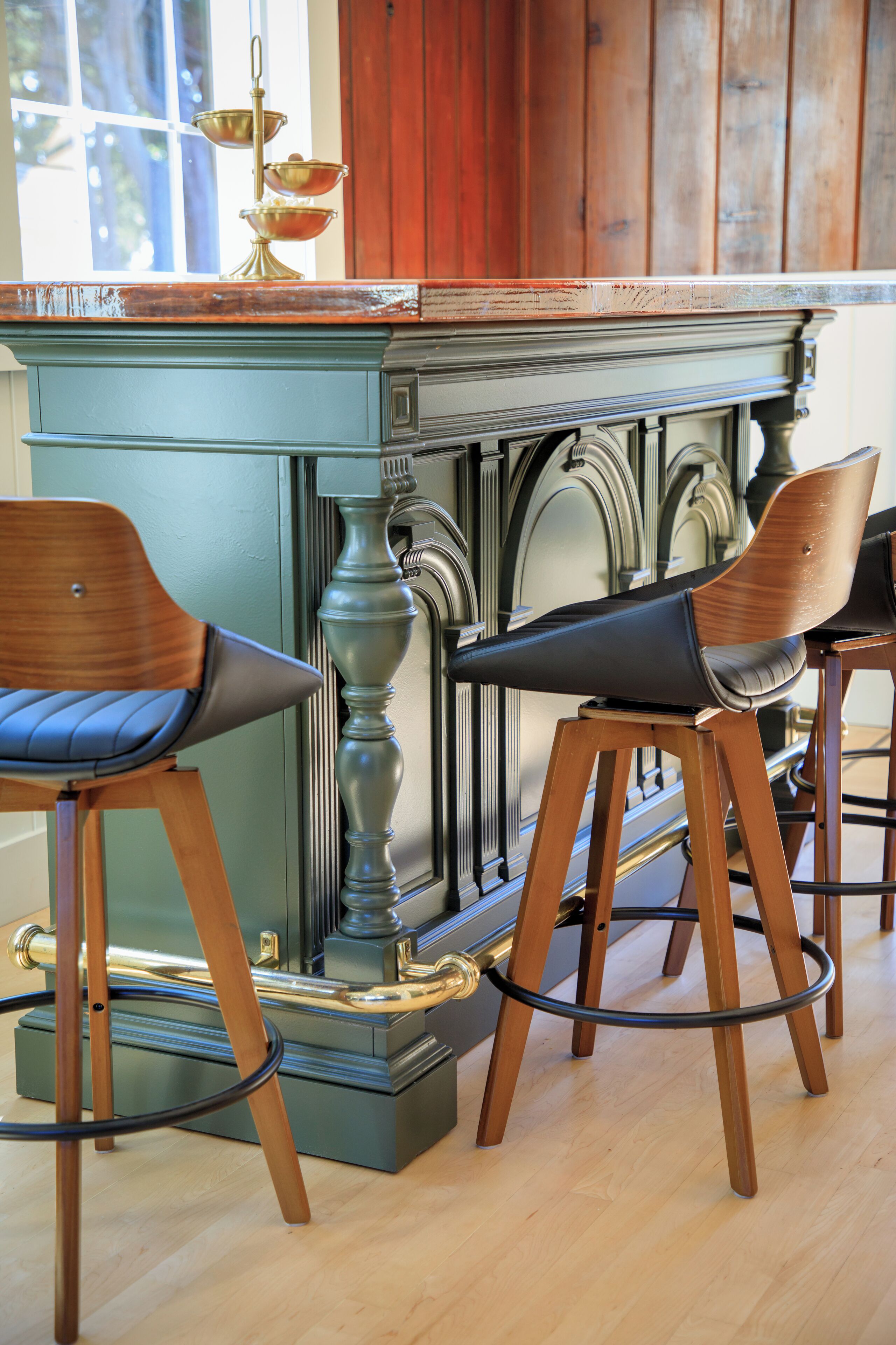 A bar area with two wooden bar stools and a green bar counter.