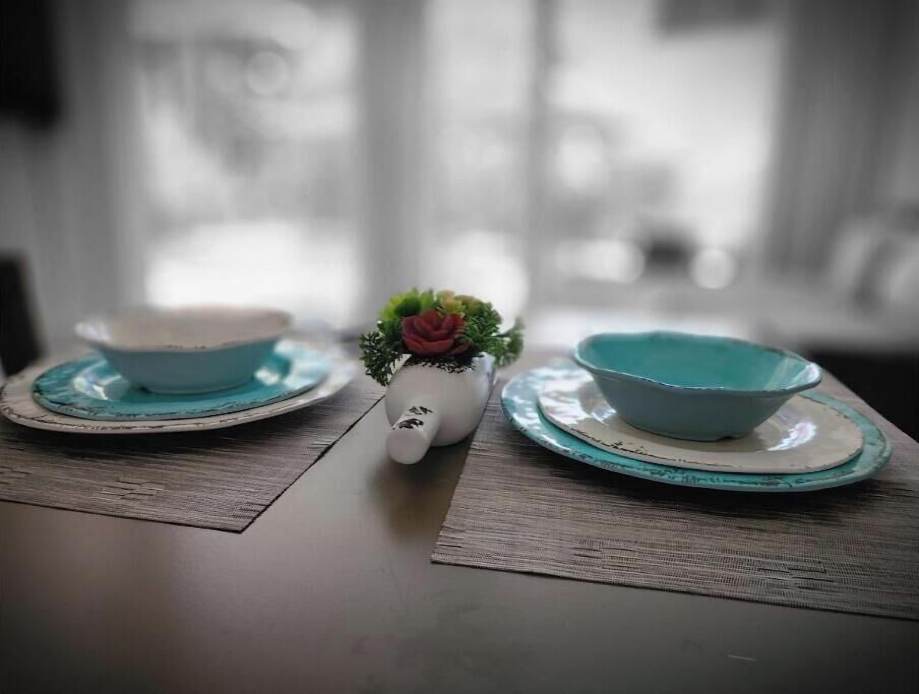 Una mesa con dos cuencos y una pequeña planta en maceta.