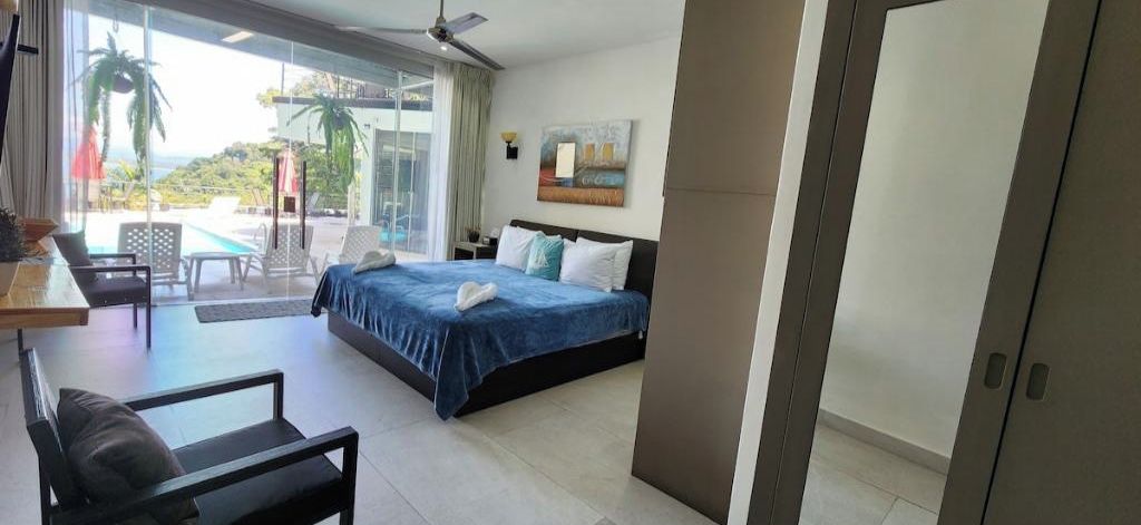 Ein Hotelzimmer mit Bett, Schreibtisch, Stuhl und Blick ins Freie.