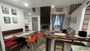 Un salon moderne comprenant un coin repas, une cheminée et une cuisine.