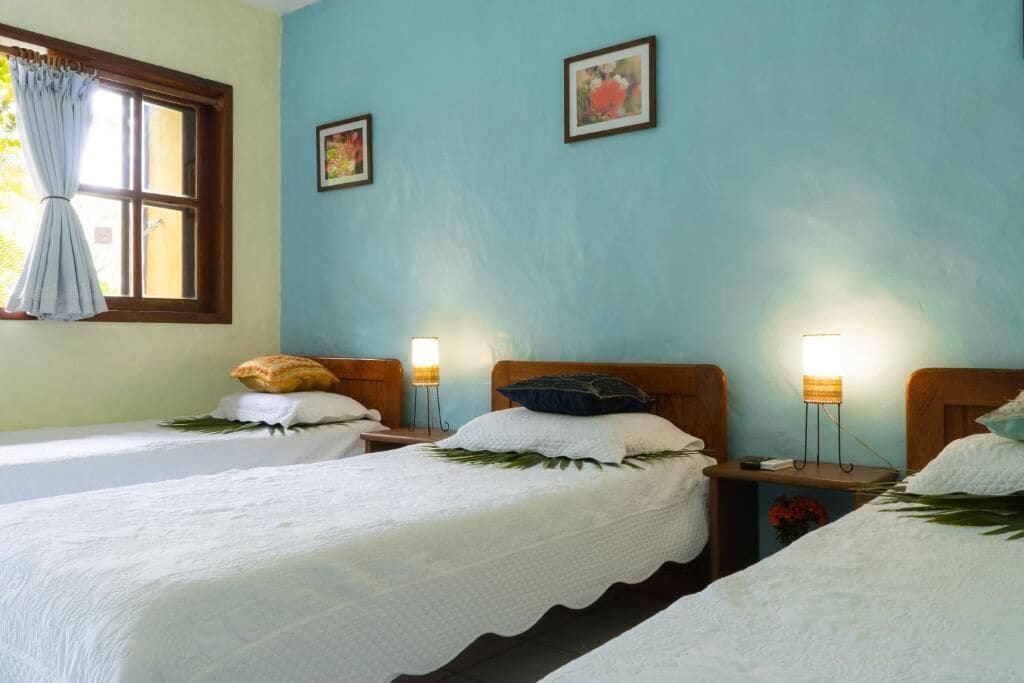 A room with two single beds, each with a pillow and a bedside lamp.