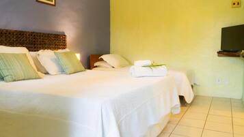 A hotel room with two beds, a television, and a wall-mounted air conditioner.