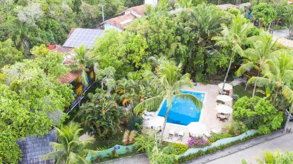 Luftaufnahme eines Anwesens mit Schwimmbad, umgeben von üppiger Vegetation und einer Solaranlage.
