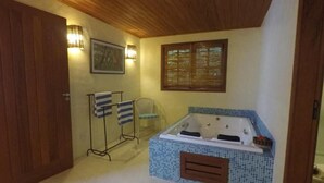 Un baño con bañera, asiento de ducha y barra para toallas.