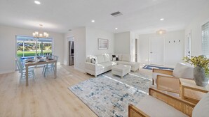 A spacious living area with a dining table, sofa, and chairs.