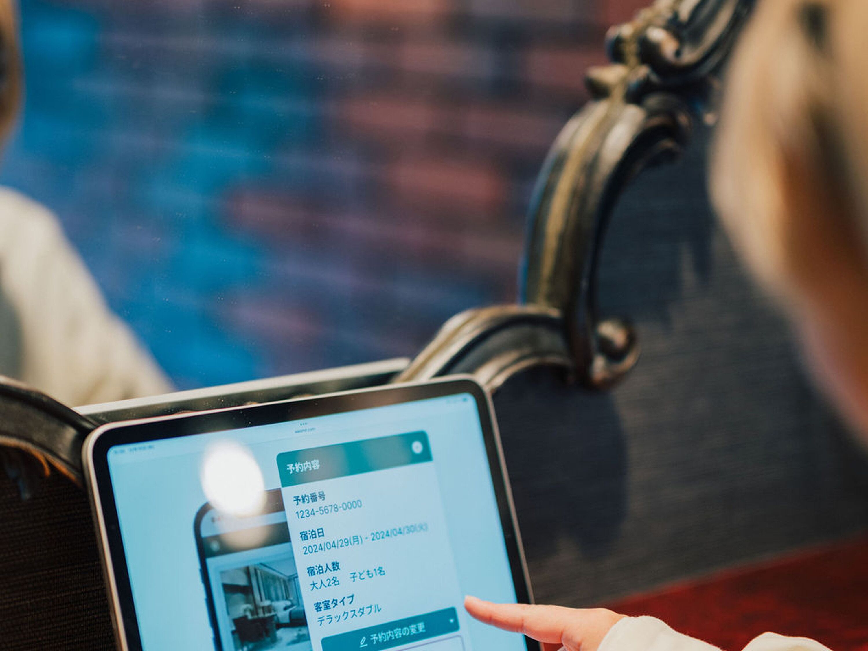 Tablet exibindo uma interface de reservas com número de quarto e datas.