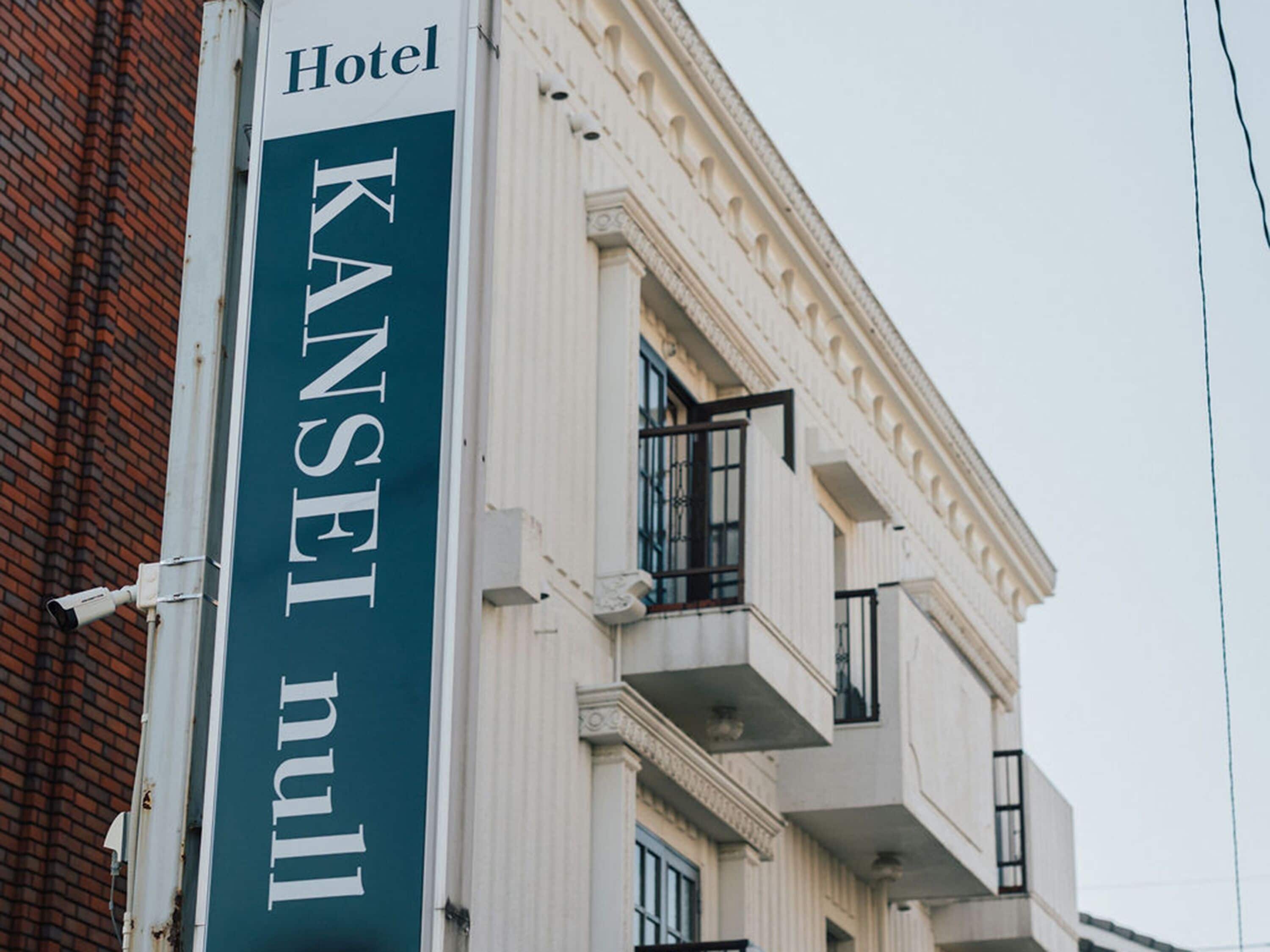 Letrero de hotel con el nombre 'KANSEI null' en la fachada de un edificio.