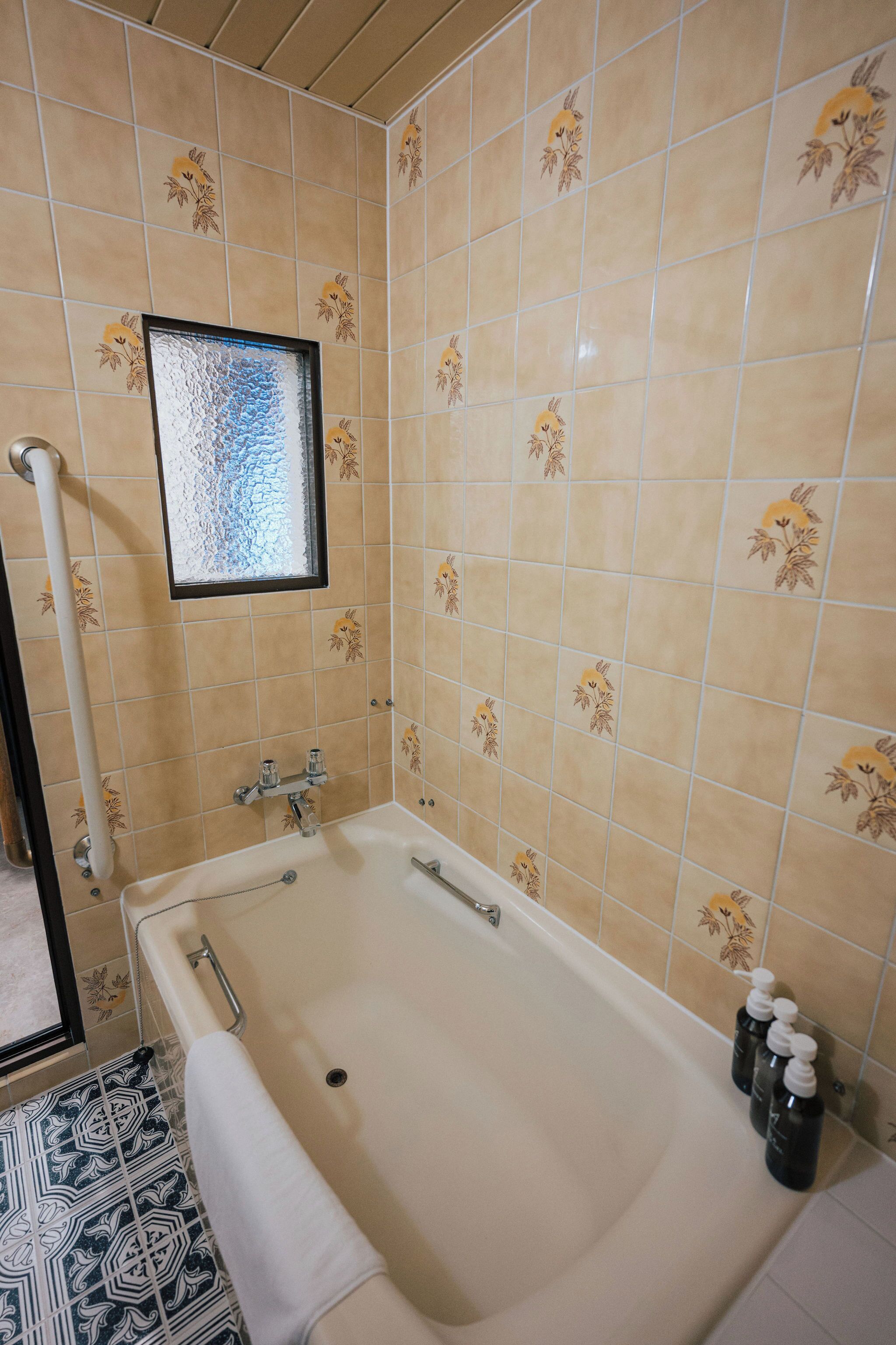 Un baño con bañera, zona de ducha y ventana con vistas.