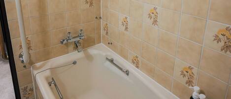 Un bagno con vasca, zona doccia e finestra vista.