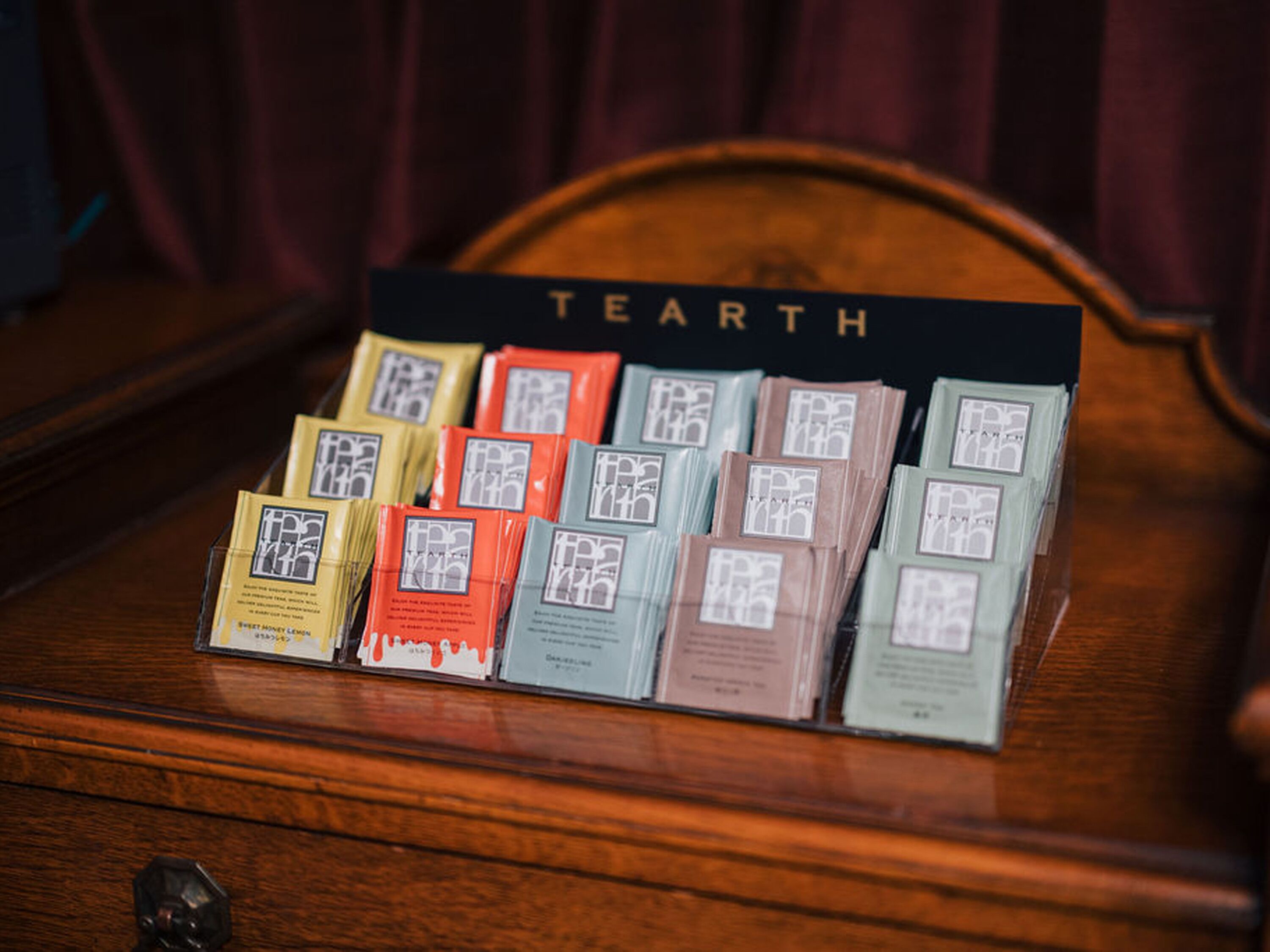 A wooden chest with a sign reading "TEARTH" above it, containing neatly arranged packets of tea.