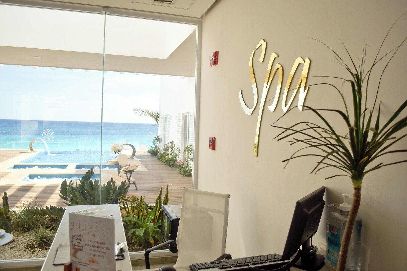 Une salle de spa avec vue sur l’océan, un bureau avec un ordinateur et une pancarte indiquant « Spa ».