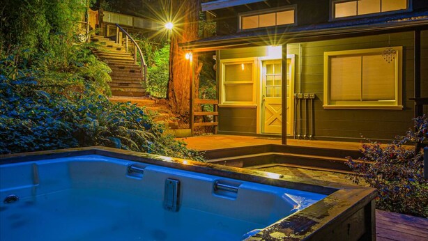 Une maison moderne dotée d’une piscine, d’un escalier menant à une terrasse et d’un grand portail de garage.