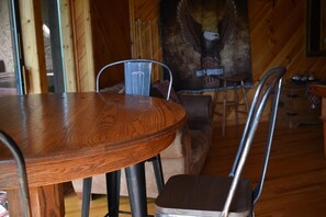 A wooden dining table with metal chairs, a wooden couch, and a wall with a large eagle mural. - 4 bedrooms and loft sleeps 12 with view  pool table 2 levels of decks and hot tub (Sevierville)