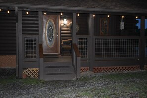 A building with a wooden facade, a large circular window, and a set of stairs leading to the entrance. - 4 bedrooms and loft sleeps 12 with view pool table 2 levels of decks and hot tub (Sevierville)