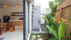 A modern kitchen with a stone backsplash, wooden cabinets, and a built-in microwave. - Peaceful villa with AC in beautiful Bali (Bali)