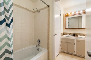 A bathroom with a shower, a bathtub, a vanity with a mirror, and a sink. - Spacious 2BR Duplex Family Group Friendly (Lynnwood)