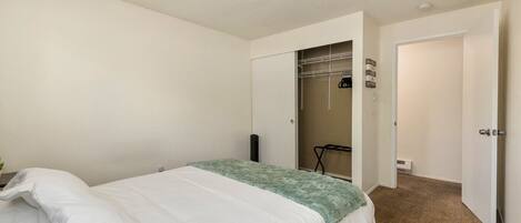Un dormitorio con cama, armario y vestidor.
