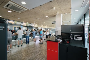 A food court with multiple counters and people standing in line. - As El Puig (Puig)