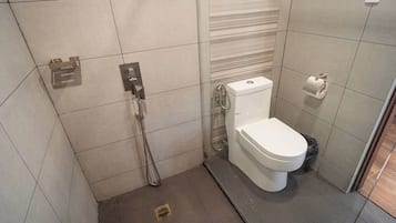 A small, modern bathroom with a toilet, a shower, and a towel rack.