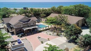 Una proprietà residenziale con piscina, diversi edifici e vista sull'oceano.