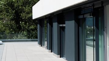 Un bâtiment moderne doté d’un toit plat, de grandes fenêtres en verre et d’un sol carrelé.