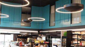Un restaurant moderne avec des meubles de couleur turquoise, un bar et un espace repas aménagé avec des tables et des chaises.