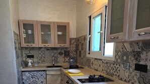 Une cuisine avec des meubles en bois, un évier et des carreaux décoratifs sur le mur derrière l’évier.