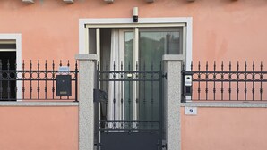 Une entrée fermée par un portail en métal et équipée d’une caméra de surveillance.