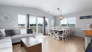 Una sala de estar moderna con sofá, mesa de centro y comedor con sillas y una mesa.