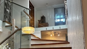 Una escalera moderna con barandillas de vidrio y escalones de madera.