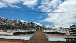 A staircase leading to a building with signage for 'Plaza Civica y Mercado' and 'José María Urbina'. - One-bedroom French style apartment in downtown Ambato (Ambato)