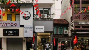 En byggnad med flera butiker på bottenvåningen, bland annat en tatueringsstudio och en exklusiv butik.