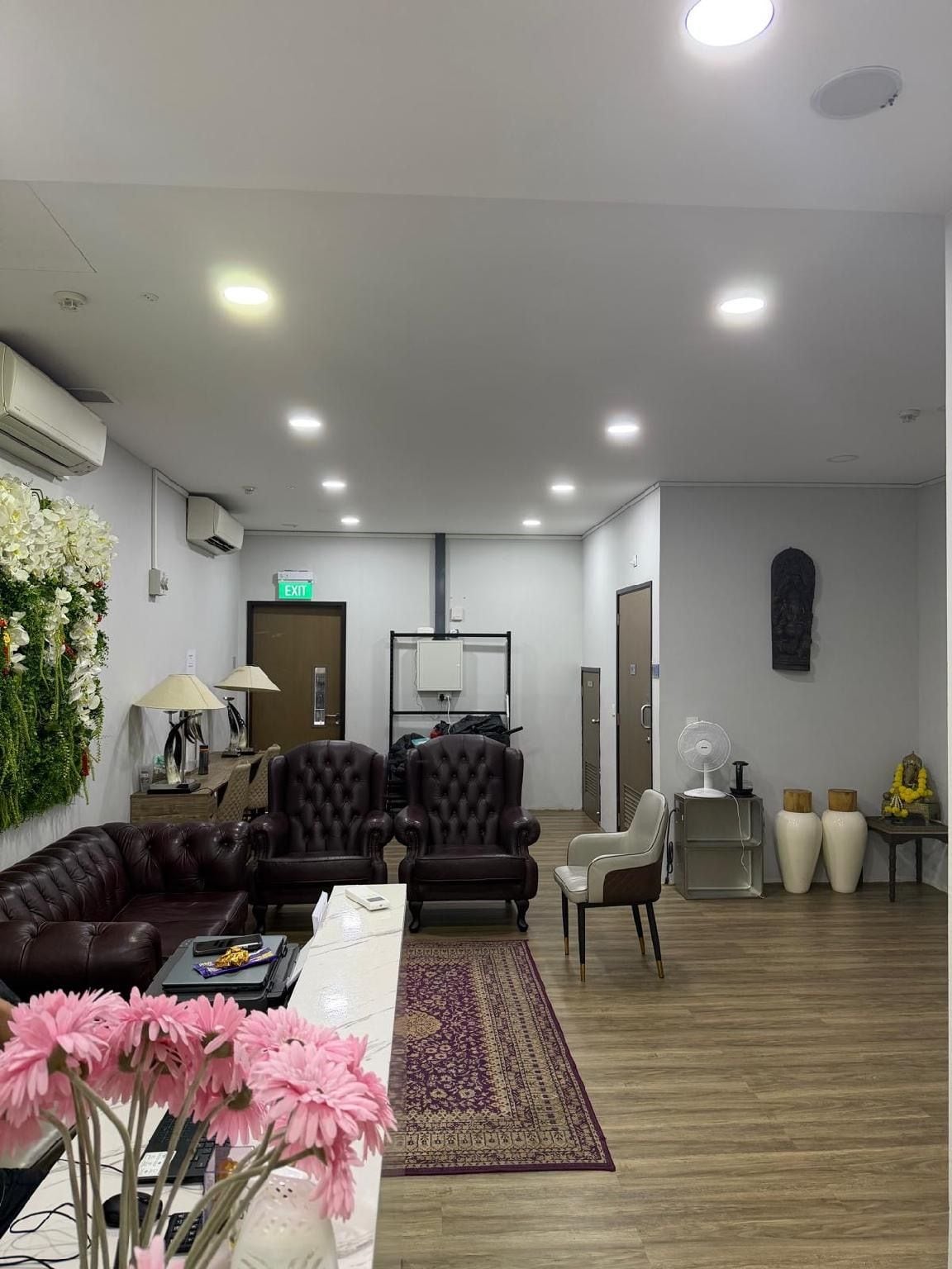A modern interior with a seating area, a reception desk, and a wall-mounted air conditioning unit.