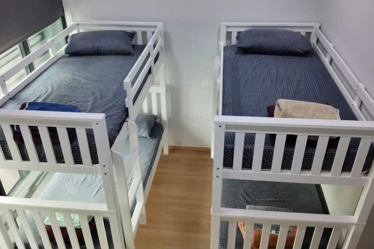 Una habitación con dos literas, cada una con colchón y almohadas.