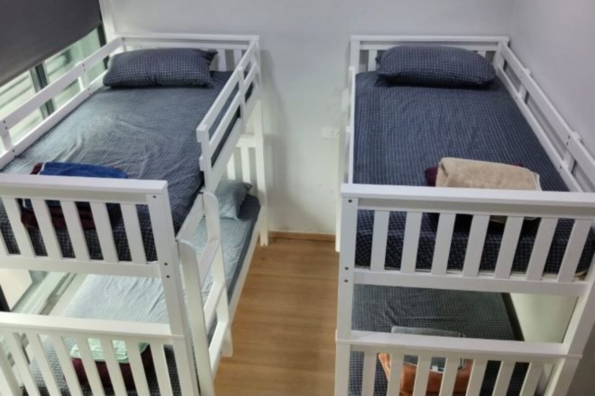 Een kamer met twee stapelbedden, elk met een matras en kussens.