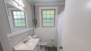 A bathroom with a white sink, toilet, and window. - Big Pet Friendly Home Near Ft Campbell (Clarksville)