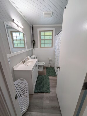 A bathroom with a white sink, toilet, and window. - Big Pet Friendly Home Near Ft Campbell (Clarksville)