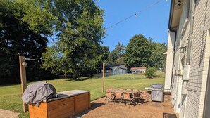An outdoor patio area with a barbecue grill, a covered storage unit, and a seating arrangement. - Big Pet Friendly Home Near Ft Campbell (Clarksville)