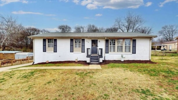 A single-story house with a front porch, a small front yard, and a clear sky. - Big Pet Friendly Home Near Ft Campbell (Clarksville)