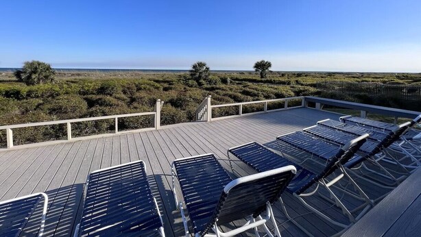A deck with sun loungers overlooking a coastal landscape. - Beachfront Escape w Balcony+Pool (Hilton Head Island)