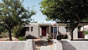 Un edificio residencial con puerta roja, buzón y placa con el número 2225.