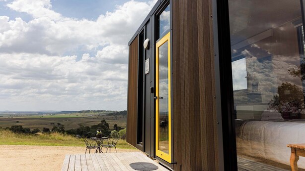 Een modern gebouw met een grote glazen deur en uitzicht op het landschap.