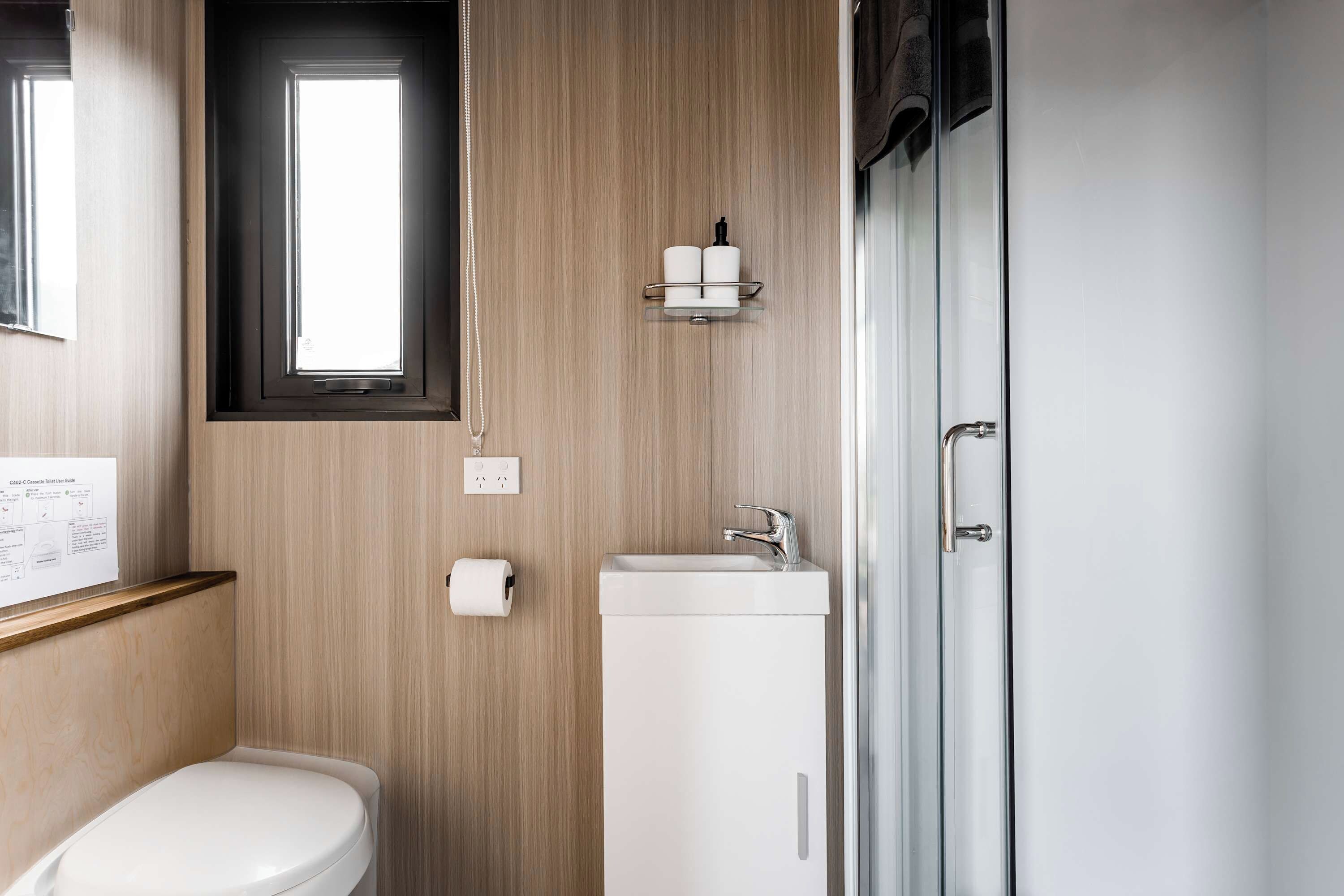 A modern bathroom with a toilet, sink, and shower.