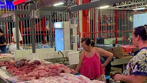 Une usine de transformation de la viande où de grandes tables présentent différents morceaux de viande.